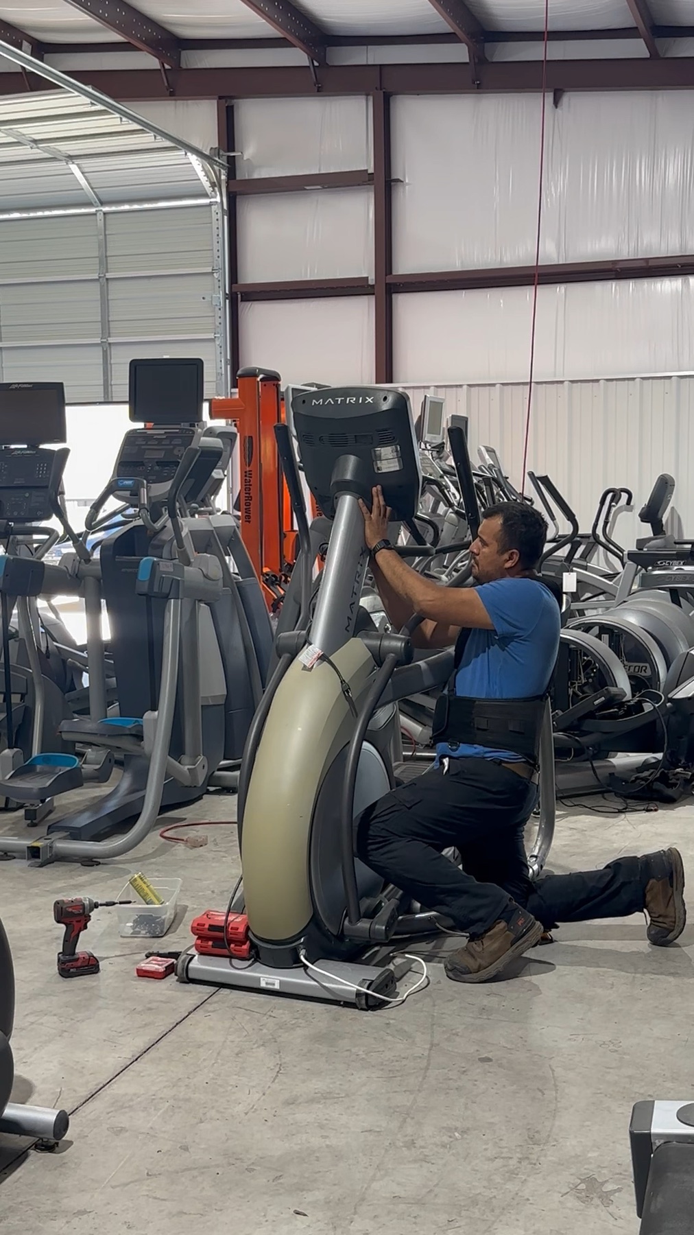 Second Chance Cardio technician servicing an elliptical in the Buford showroom